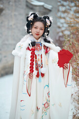 Asian girl wearing Ming Dynasty Hanfu outdoors after heavy snow
