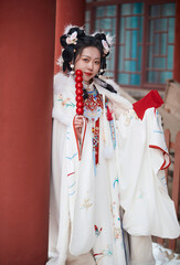 Asian girl wearing Ming Dynasty Hanfu outdoors after heavy snow