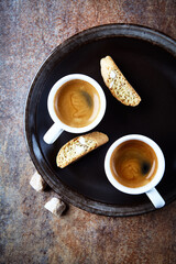 Cantuccini (Italian cookie) and Two Cups Of Coffee on rustic stone background. Top view. Copy space.	