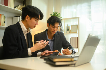 Professional advisor and client reviewing and discussing contract terms in a bright office