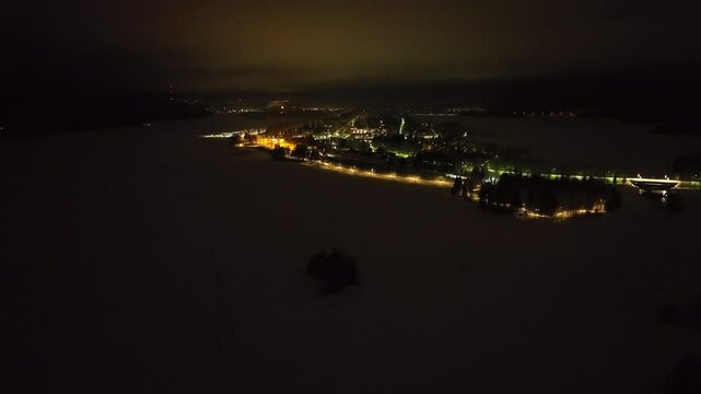Aerial view around the illuminated Nurmes town, winter night in Finland