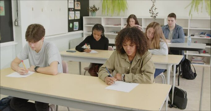 High School - College Students Writing Assignment Essay. Academic Studies. Diverse Male and Female Students Write Notes, Study, Mid Term Final Exam Test Answers in Class. Educational Development