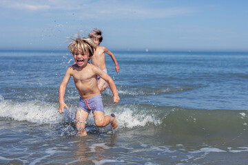 Pure Joy: Kids Splash in Sunny Ocean Waves
