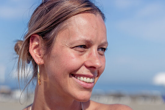 Close-up of a smiling woman looking away with a cheerful expression.
