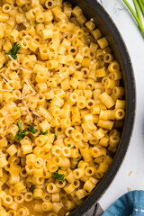 Hot Parmesan ditalini pasta soup garnished with parsley in a pot