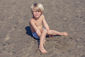 Smiling Child Enjoys a Sandy Beach Day in Sunshine