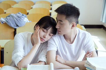 Obraz premium Young couple cuddling each other in the university study room