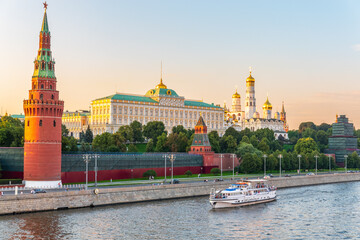 Obraz premium View of Kremlin with Vodovzvodnaya tower, Grand Kremlin Palace from repaired Bolshoy Kamenny Bridge in Moscow city on sunny summer day. Cruise ship sails on the Moscow river