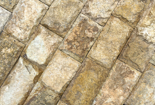 A brick wall with a pattern of brown and gray bricks