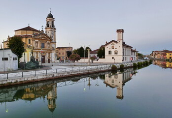 Fototapeta premium Gaggiano, Milan, Italy: Gaggiano, historic town with colorful buildings along the Naviglio Grande, at summer
