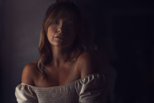 Low light portrait of woman over dark background