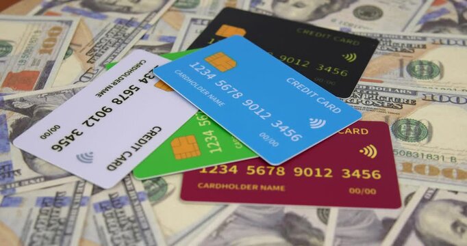 Close up of credit cards and stacks of 100 dollar bills on a rotating table.
