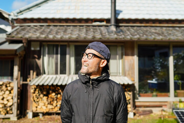 古民家の庭で笑顔の男性