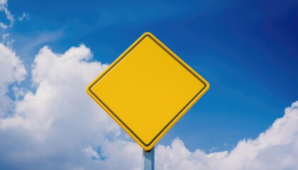 A close-up of a bright yellow sign against a cloudy sky 