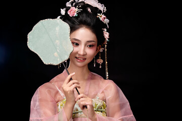 Seated woman wearing Tang Dynasty hairpin flower lady's dress and holding a light fan