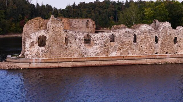 Aerial close up of Koknese Castle ruin complex in Koknese, Latvia, on the Daugava river valley drone footage at sunset