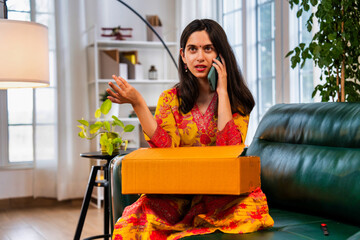 Frustrated Indian girl in salwar kameez on phone discussing an issue with customer care at home