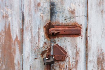 Old rusty padlock on the metal door