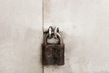 Old rusty padlock on the metal door