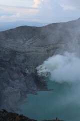 Fototapeta premium Breathtaking view of a volcanic crater with emission of smoke