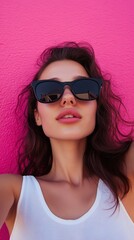 Naklejka premium A portrait of a beautiful woman with sunglasses, showcasing summer fashion and style, with long brunette hair, makeup, and glamour in a red and black studio setting