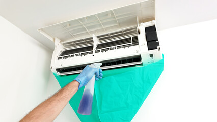 Man cleaning and maintaining air condition unit at Man cleaning and maintaining air condition unit...