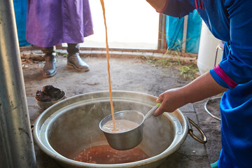 The process of brewing Mongolian milk tea using traditional techniques in a yurt