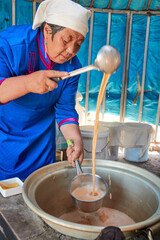 The process of brewing Mongolian milk tea using traditional techniques in a yurt