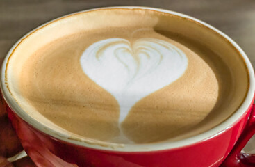 Hot cappuccino coffee with a heart pattern on the foam