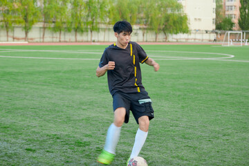 Fototapeta premium Athletes playing soccer on the outdoor football field