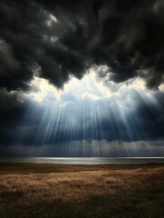 Dramatic light rays shining through dark clouds over a grass field and sea, creating a hopeful and scenic landscape