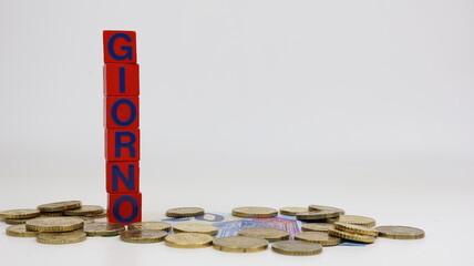 Parola singola GIORNO scritta su cubi di legno con monete in euro su sfondo bianco e spazio per la...