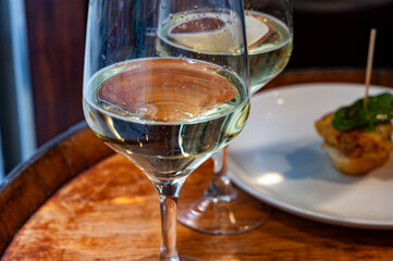 Glass of txakoli or chacolí slightly sparkling very dry white wine produced in Spanish Basque Country in typical pinchos bar in old part of San Sebastian or Donostia, Spain