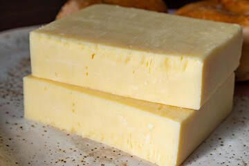 Block of aged cheddar cheese, the most popular type of cheese in United Kingdom and USA, natural cheese from cow milk