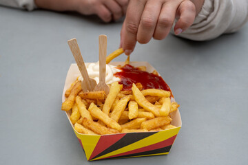 Belgian street and fast food, paper box in colors of Belgian flag with fried potato frit chips and...