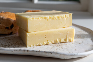 Block of aged cheddar cheese, the most popular type of cheese in United Kingdom and USA, natural cheese from cow milk