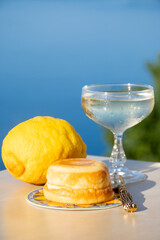 Sweet italian dessert ricotta cheese baked with lemon and glasses of Prosecco sparkling wine served on Ligurian coast with view on sea, summer in Italy