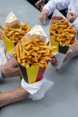 Belgian street and fast food, paper cone bag in colors of Belgian flag with fried potato frit chips...