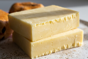 Block of aged cheddar cheese, the most popular type of cheese in United Kingdom and USA, natural cheese from cow milk