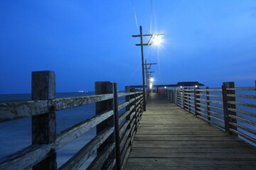 Naklejka premium wooden bridge that extends to the beach