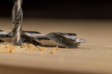 metal drill bit and pine wood board during operation