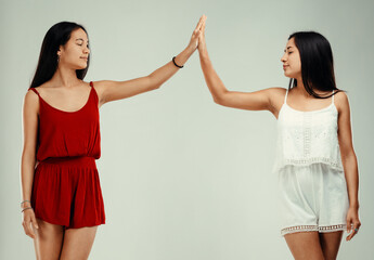 Two young women giving high five celebrating success