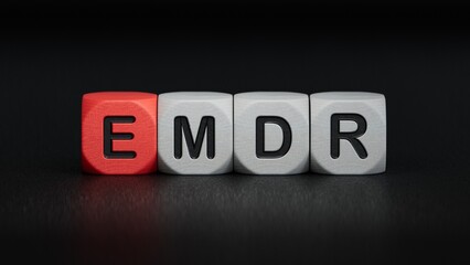 The text EMDR word Eye Movement Desensitization is written on notepad . Medical concept.close up of wooden elements,Business Concept.3D rendering on black background.