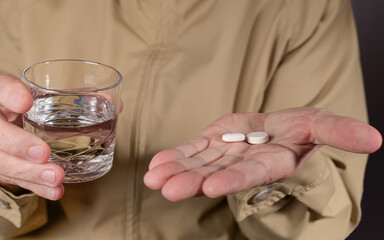 main humaine avec médicaments et verre d'eau