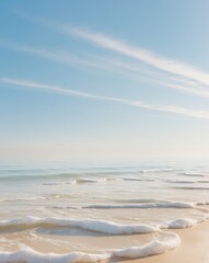 Fototapeta premium Tranquil seascape with foamy waves lapping at the sandy shore under a bright blue sky