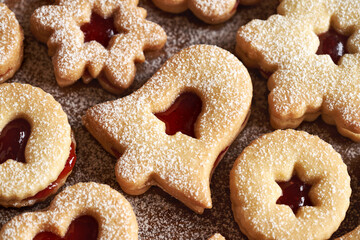 Bell shaped Linzer Christmas cookie filled with strawberry marmalade and dusted with powdered sugar