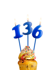 Blue number 136 candle - Birthday card on a white background.