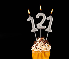 Number 121 shaped candles - Birthday cupcake on black background.