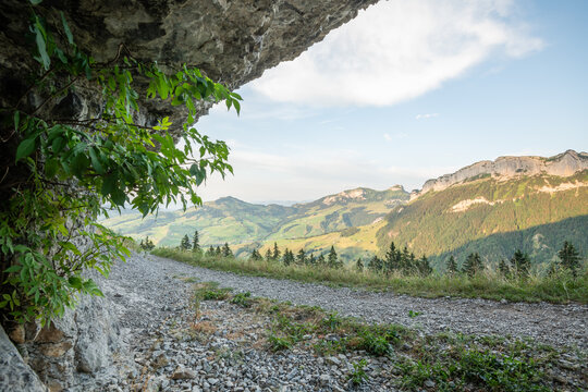 Hiking trail near Aescher Guesthouse on the mountain (Berggasthaus &Auml;scher, Aescher). Cliff at the right side, valley with mountains at the right side and background. Soft afternoon light. Swiss Alpste