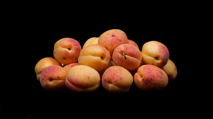 Close-up image of apricot fruit on black background.